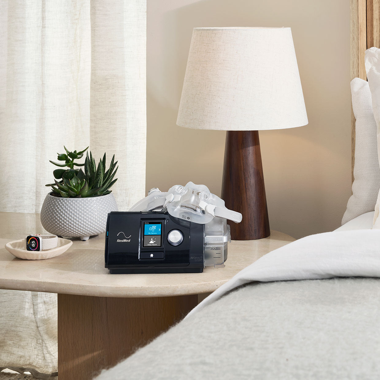 AirSense 10 CPAP machine on a nightstand with a full face mask resting on top
