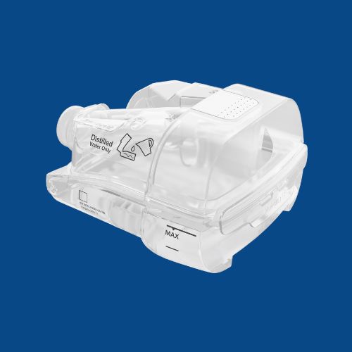 Clear plastic humidifier water tank for CPAP machines against a dark blue background