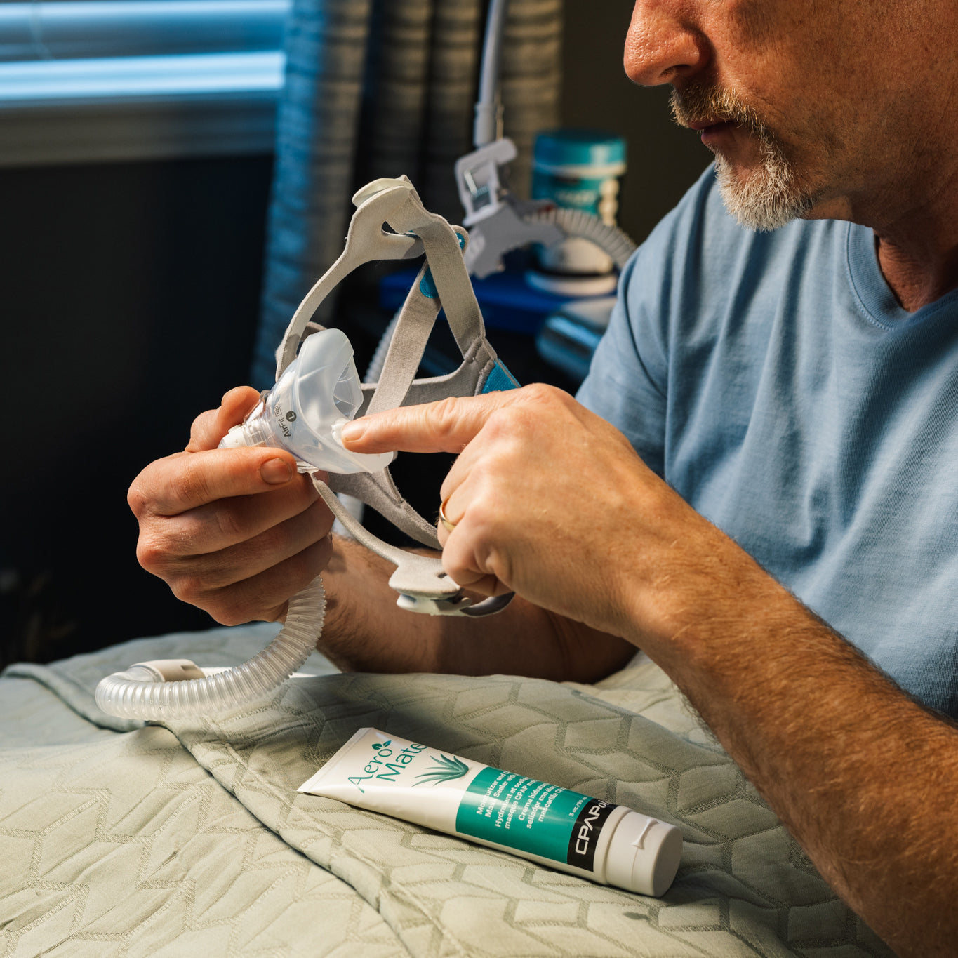 Person putting CPAPology AeroMate CPAP Moisturizing Lotion on their ResMed AirFit CPAP mask