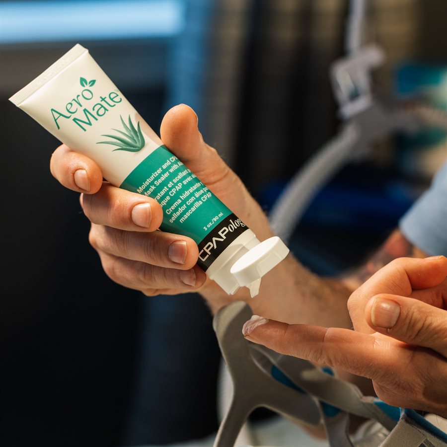 Person holding tube of CPAPology AeroMate CPAP Moisturizing Lotion