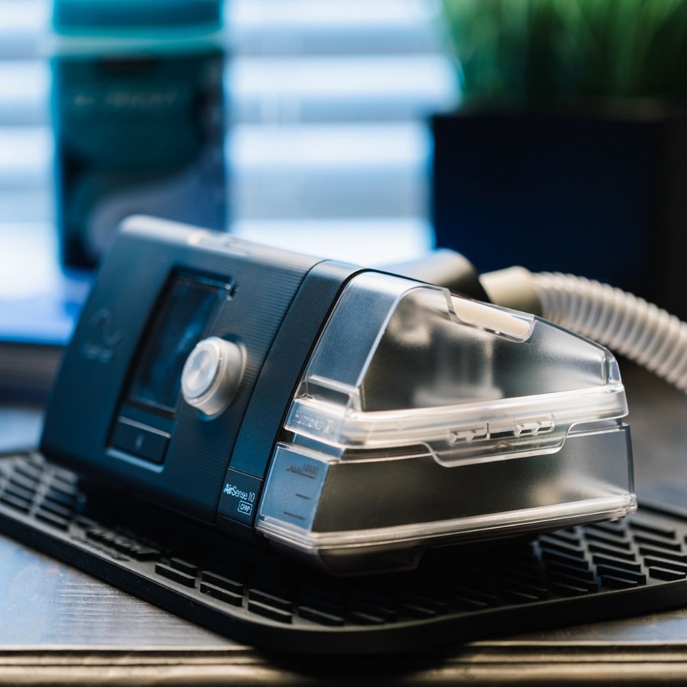 CPAPology Black Knight Non-Slip Protector Mat for CPAP Machines shown with AirSense 10 on it