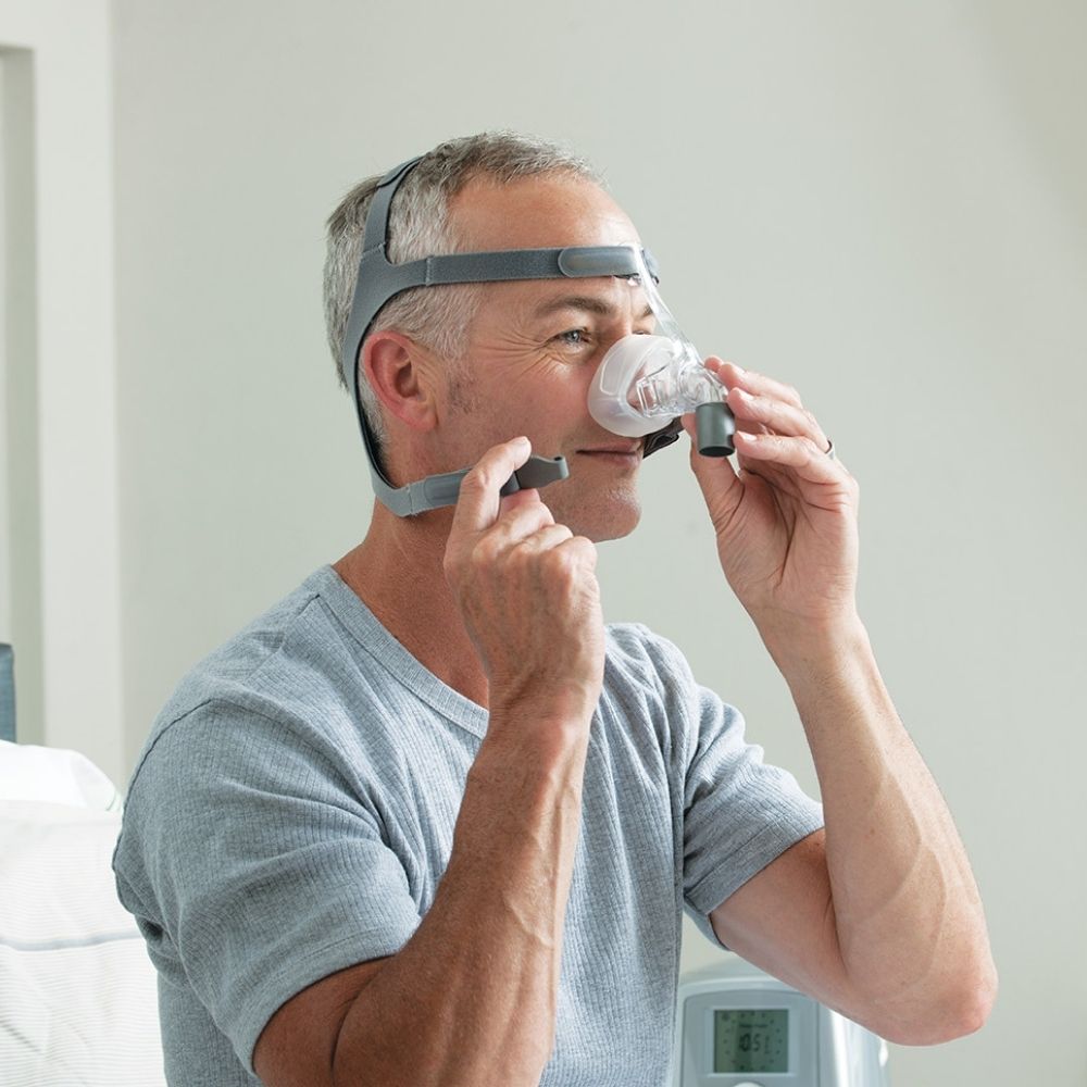 Man clipping on the F&P Eson Nasal Mask