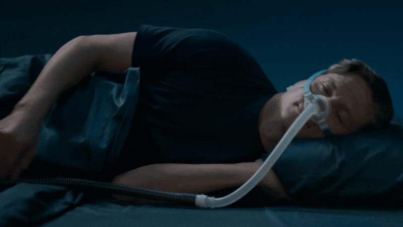 Man sleeping comfortably on his side wearing the F&P Nova Nasal CPAP Mask