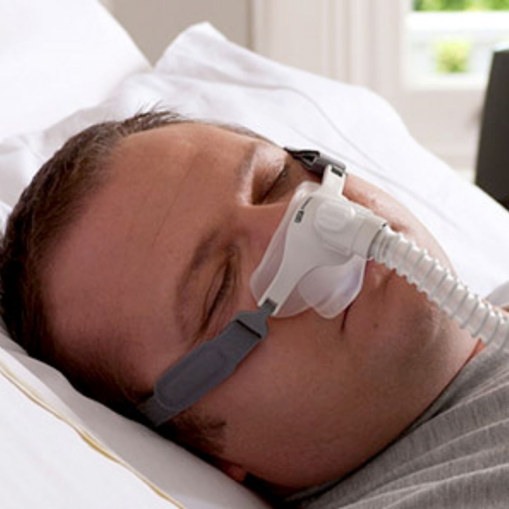 Person sleeping using a F&P Pilairo Q Nasal Pillow Mask
