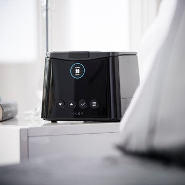 F&P SleepStyle CPAP Machine on a white surface with a blurred background