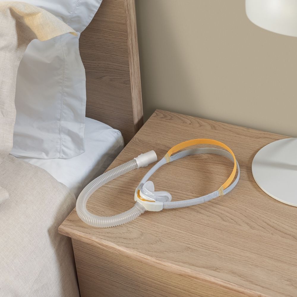 F&P Solo Nasal Mask with tube on wooden nightstand