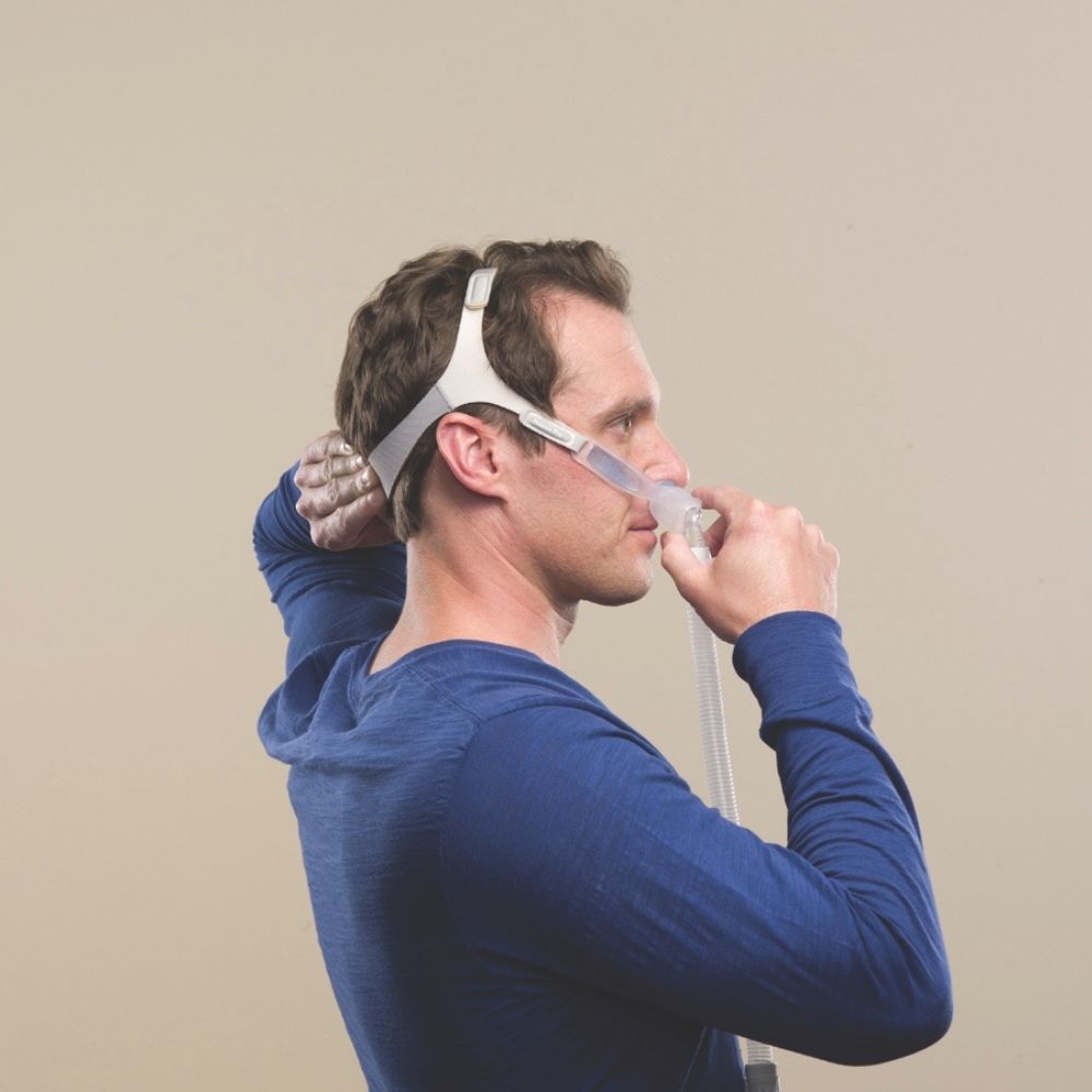 Person putting on the Philips Nuance Pro Gel Pillows Mask