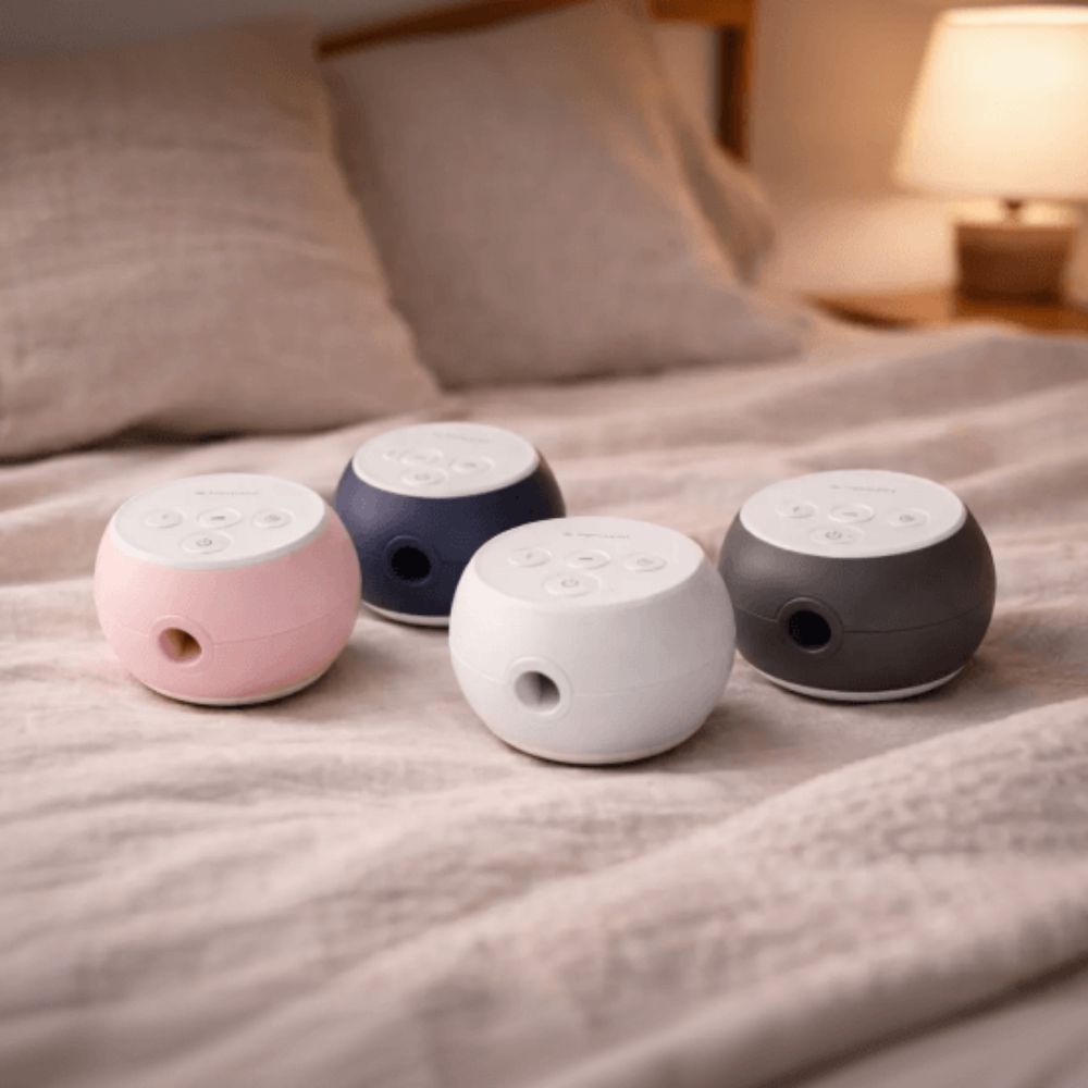 Four Transcend Micro 510 CPAP devices in pink, blue, white, and grey on a bed