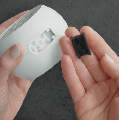 Person holding the small PureFresh filter in one hand and the Transcend Micro CPAP machine in the other